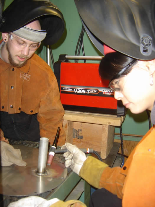 Students setting up a weld prior to welding metal. 